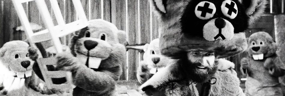 Beavers fighting with man in raccoon costume. Still from Hundreds of Beavers film.