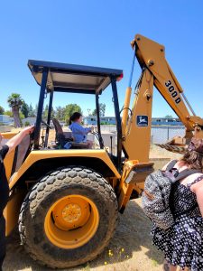 Joel Greenzeiger pretends to be a gravedigger as he sits on the backhoe at Memory Garden Odd Fellows Cemetery in Livermore, 5/26/25